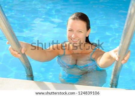 Young attractive female beauty posing in the swimming pool