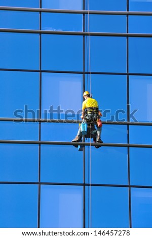 Washer wash the windows of modern skyscraper