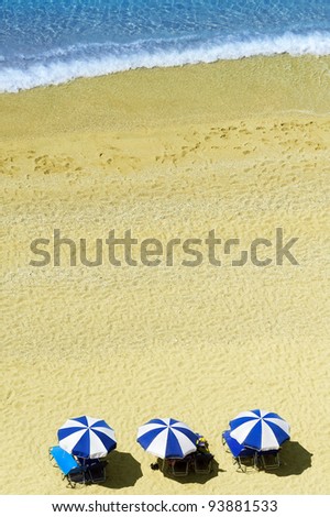 Beach scene with beautiful turquoise sea and yellow sand in front of sun umbrellas