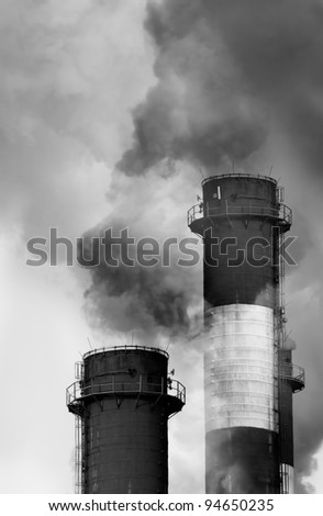 Close-up image of industrial chimneys releasing toxic smog clouds to atmosphere