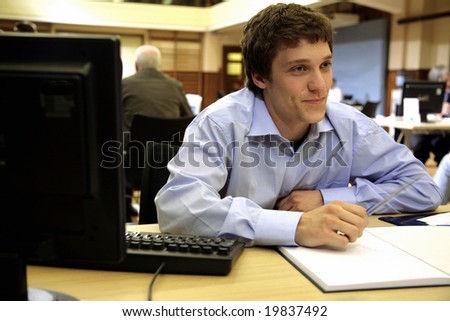 A young worker/Student smiles whilst working on a new project