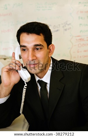 an asian businessman answers the phone