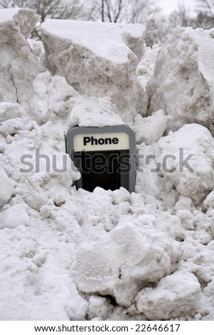 An old pay phone with piles of snow around it.