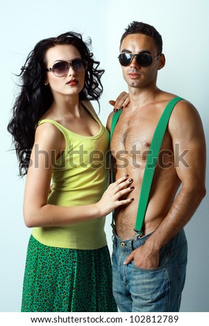 Portrait of sexy stylish young couple macho man and woman both wearing sunglasses