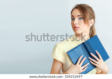 Attractive young student going back to school college smiling and holding books.