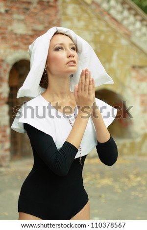 sexy a hot caucasian girl wearing a nun outfit in sunny day outdoor praying looking to the sky