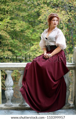 thoughtful Young lady in old fashion dress outdoor sitting