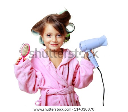 cute five years old Girl with a comb in hair curlers on a white background