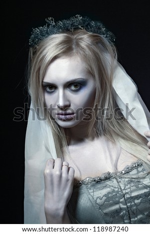 Portrait of beautiful zombie corpse bride looked scary and standing at dark background. shot in studio