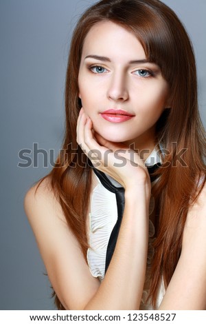 Portrait of a beautiful young woman touching her face thinking