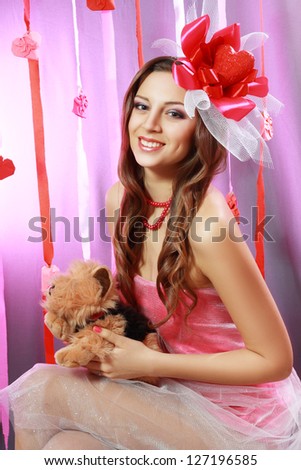 beautiful Valentines woman playful joyful and excited smiling holds puppy toy dog