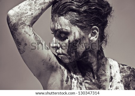 a close up of a woman\'s face and hands covered in mud