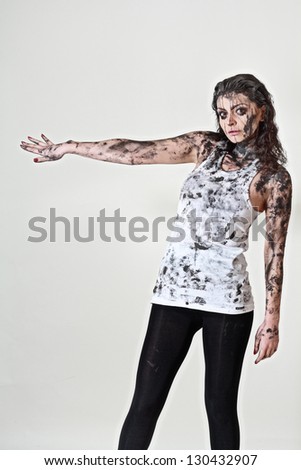 scary crazy woman with face and body covered in mud