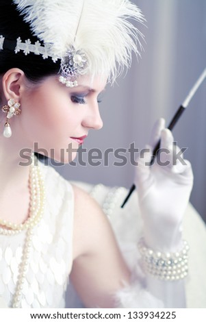 Beautiful young woman close up portrait in retro flapper style headband Vogue style vintage