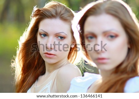 two Beautiful woman twins in the morning park focus on one of the sisters