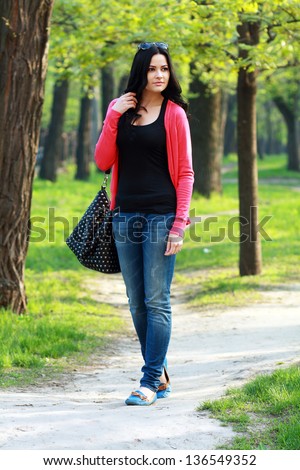 beautiful university student walking on outside campus, green park