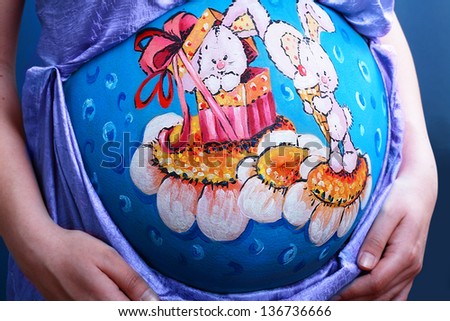 pregnant woman with body arti painting on her belly isolated on white background