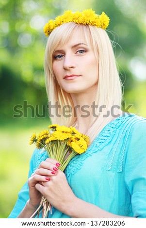 Closeup portrait of pretty young lady with yellow flowers in a park - Outdoor
