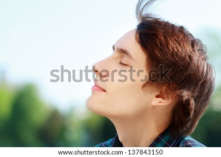 Young Attractive Man Breathing Fresh Air Outdoors Showing His Face To The Wind