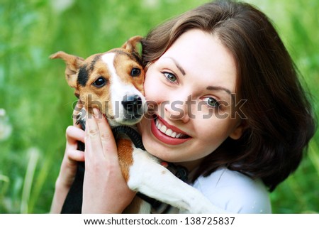 woman beautiful young happy with dark hair in striped sweater holding small dog Jack Russell Terrier