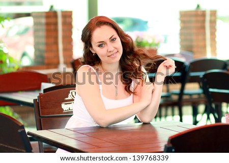 Style woman sitting on the bench in the cafe