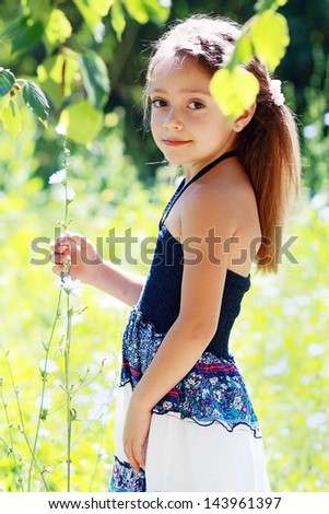 beautiful little six years old girl on the meadow in summer day