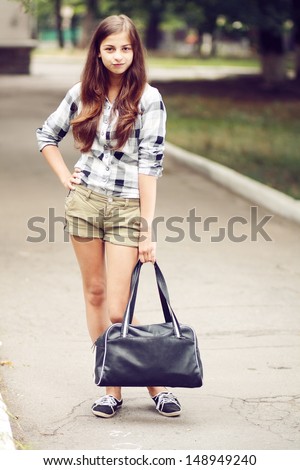 Schoolgirl Outdoor with book bag. Back to School. Soft colors