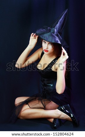 Charming halloween witch over dark background.