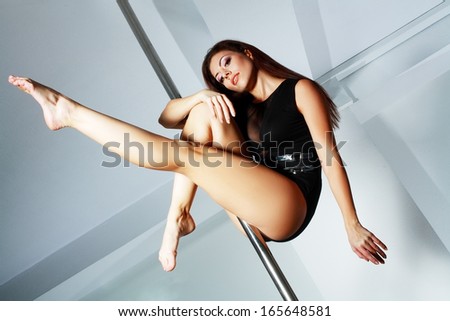 Young slim pole dance woman in dance studio
