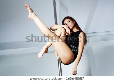 Young slim pole dance woman in dance studio