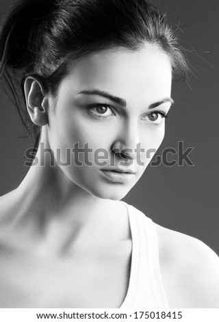 portrait of a beautiful woman in white top female fashion model posing over grey background