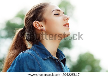 Young attractive woman breathing fresh air outdoors showing his face to the wind