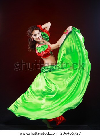 professional dancer beautiful woman dancing in green and red costume on black