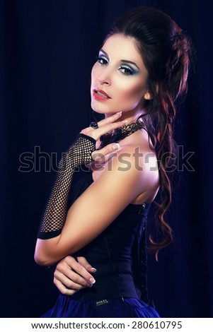 beautiful fashion vampire victorian style woman posing over dark background