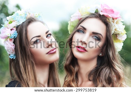 Renaissance - two nymphs in colorful flower wreaths close up