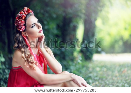 beautiful fairy: filtered image of brunette pretty girl in lotus flower crown and pink makeup posing gracefully on green outdoors copy space background
