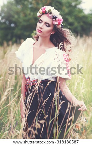 beautiful female model in slovakian national costume posing outdoor in flower head crown