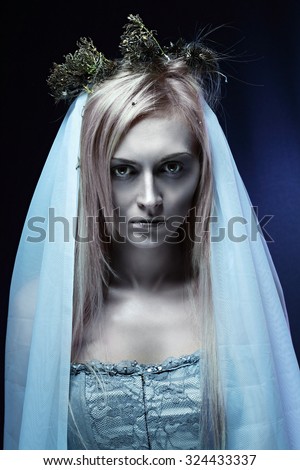 Portrait of beautiful zombie corpse bride looked scary and standing at dark background. Halloween concept