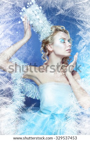 snow-queen. Young winter woman in creative image with silver blue artistic make-up and perfect hairstyle.