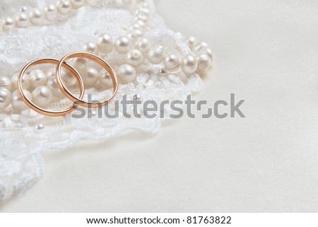 stock photo Pair of golden wedding rings over invitation card decorated