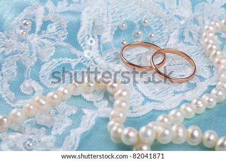 stock photo Pair of golden wedding rings over invitation card decorated 