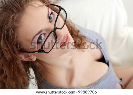 sexy young woman face with perfect make up looking over glasses over white background