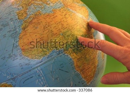 hand pointing at world globe