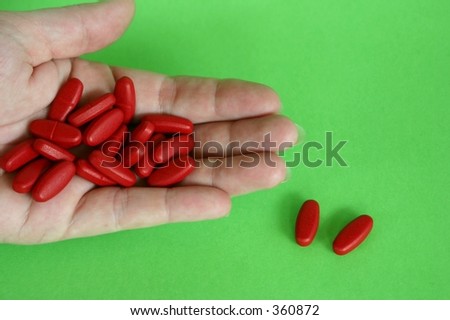 Hand holding multi vitamin capsules