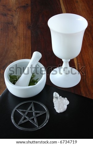closeup of wicca spell tools and book of shadows with mortar and pestle