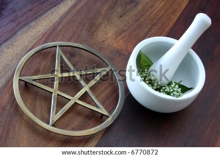 closeup of wicca spell tools and book of shadows with mortar and pestle