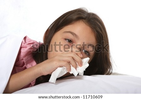 young girl / child sick in bed with a cold using tissues