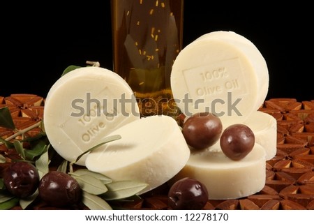 natural olive oil soap olives branch and oil against wooden mat