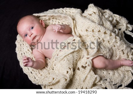 young healthy baby wrapped in woolen shawl