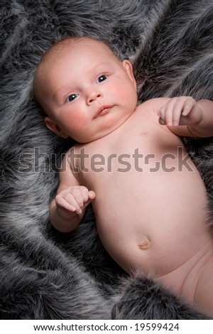 young healthy baby girl on black and white fur rug